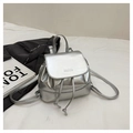 Detail of silver metallic PU backpack featuring a drawstring closure and debossed mim logo - Silver