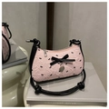 Détail du sac en dentelle rose avec nœuds noirs, pendentif cœur et bandoulière - Rose