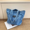 Light blue washed denim tote bag with functional exterior pockets and fashion label - Denim Light Blue