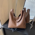 Bolso tote trenzado marrón con patrón Intrecciato y estructura trapezoide suave en estudio - Marrón