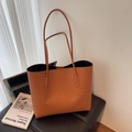 Orangefarbene Tragetasche aus Kunstleder mit Logoprägung und schmalen Schultergurten - Braun