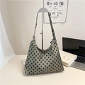 Bolso tote verde grisáceo con lunares y correa ancha sobre soporte de metal plateado - Verde