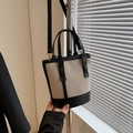 Bolso bombonera de lona beige y cuero negro con elegantes detalles dorados - Negro
