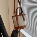 Bolso tipo cubo de lona beige con ribete de cuero marrón y correa ajustable - Marrón