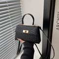 Elegante borsa a mano in pelle nera martellata con chiusura dorata e tracolla sottile - Nero