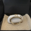 White pebbled leather crossbody bag with a large gold ring handle in a black gift box - White