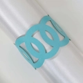 Light blue laser-cut paper napkin ring with circular hollow design on white cloth - Tiffany Blue