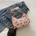 Pink corduroy crescent bag with strawberry print and gold metal bar detail on denim - Pink