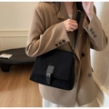 Detalle de bolso bandolera de ante negro con hebilla metálica dorada de moda - Negro