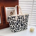 Detailed macro view of black and white leopard print on a premium canvas tote handbag - Black