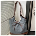 Détail d'un sac fourre-tout en denim avec anses en cuir marron et nœud décoratif - Grand Denim Café Sans Pendentif