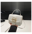 Detail view of white leather crossbody bag featuring a large gold square metal buckle closure - White