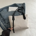 Minimalistische cremefarbene Canvas-Tasche mit schwarzen Lederriemen und Zierbändern - Hellgrau