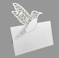 Détail macro du marque-place colibri découpé au laser avec motifs floraux évidés - Blanc