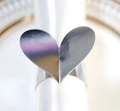 Elegant heart-shaped silver metal napkin ring on white cloth for wedding decor - Reflective Silver