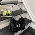 Dettaglio della borsa tote in ecopelliccia con strisce verticali e fiocco d'argento - Nero