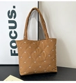 Detalle de bolso tote acolchado marrón con patrones de lazos blancos y bandolera - Marrón