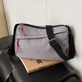 Purple nylon crossbody bag with grid pattern and red zipper pulls on yellow books - Gray