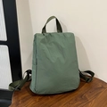 Zaino in nylon verde salvia con trama pieghettata e spallacci regolabili su legno - Verde