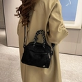Sac bandoulière noir mat avec poignée nouée porté sur un trench-coat beige - Noir
