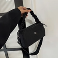Minimalist black nylon handbag with silver clover badge and pleated handle in crossbody style - Black