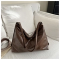 Detail view of the brown vintage PU leather tote bag with metal eyelets and long strap - Brown