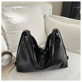 Detail of minimalist black large-capacity tote bag in premium PU leather on white sofa - Black