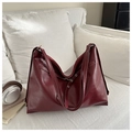 Detail of burgundy faux leather tote bag with silver metal eyelets and soft texture - Red