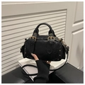 Gros plan d'un sac bowling rétro noir avec clous dorés et boucles métalliques - Noir