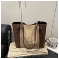 Detalle de correa ajustable con hebilla dorada en el bolso tote beige y marrón - café