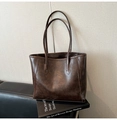 Dettaglio della borsa tote marrone scuro con texture vintage effetto cerato e cuciture - Caffè Senza Ciondolo