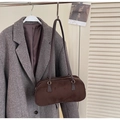 Dettaglio del tessuto scamosciato morbido e forma a cuscino vintage sulla borsa a spalla marrone - caffè