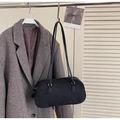 Dettaglio di una borsa Boston nera in finta pelle scamosciata appesa con cappotto - Nero