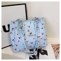 Dettaglio borsa tote in tela azzurra con stampa a ciliegia e tracolla a catena d'argento - Blu