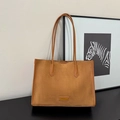 Minimalistische bruine suède shopper met dunne bandjes en fashion tag in een studio - Tan