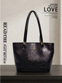 Close-up of black retro leather tote bag with gold logo text and smooth texture - Black
