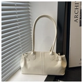 Detail view of the elegant cream white faux leather tote bag on a window sill - Off White