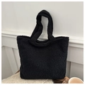 Detailed view of black fluffy fleece tote bag texture with minimalist shoulder straps - Black