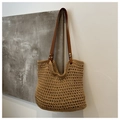 Close-up of hollow mesh knit texture and brown faux leather straps on a beach tote bag - Khaki
