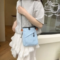 Détail d'un sac bandoulière en nylon bleu clair avec sangles orange et zip noir robuste - Bleu