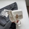 Bolso bandolera blanco minimalista con cierre giratorio dorado sobre chaqueta gris - Blanco Roto