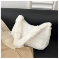 Close-up of white plush crescent shoulder bag on black leather sofa with trench coat - White