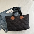 Minimalist black quilted tote bag with brown floral accents and nylon straps for women - Black