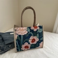 Artistic vintage floral print canvas tote bag with brown handles on white bedding - Blue