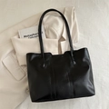 Sac fourre-tout minimaliste en cuir noir pour femme avec blazer et livre en vue lifestyle - Noir