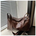 Detail view of large dark brown leather tote bag with soft texture and wide shoulder strap - Coffee