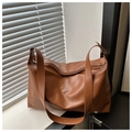 Detail view of large brown minimalist shoulder bag with smooth PU finish and zipper closure - Brown