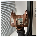 Détail du jacquard floral vintage et du cuir marron sur un sac à bandoulière élégant - Marron