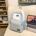 Blue and white nylon backpack with mountain patches and mesh side pockets on a sofa - Blue