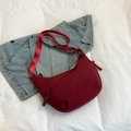 Sac bandoulière demi-lune rouge foncé en nylon avec large sangle sur jean - Rouge